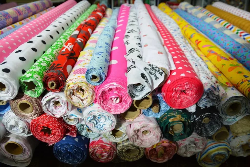 Bolts of printed fabric stacked in a textile warehouse